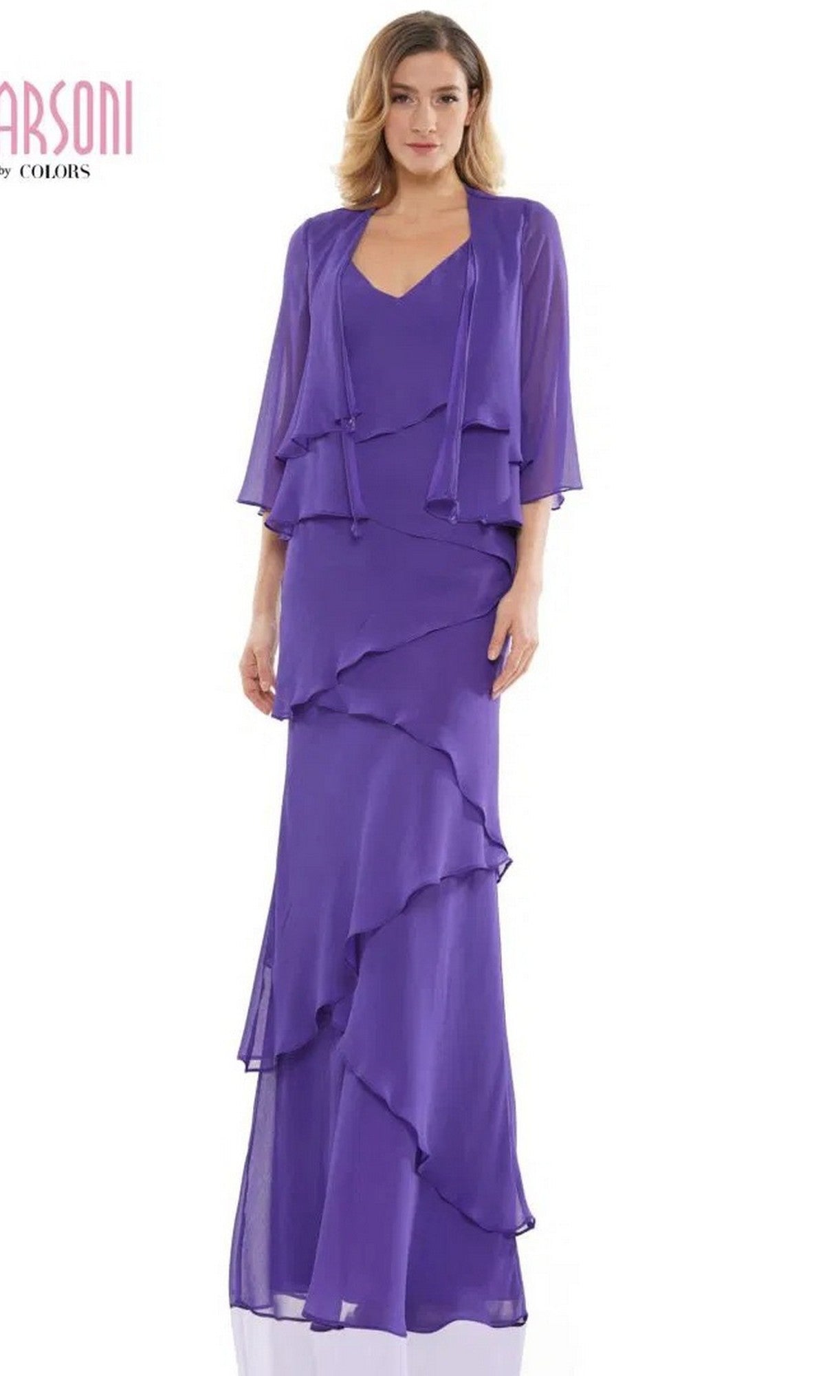 A woman stands against a white background wearing the Marsoni M309 long formal dress in iris, featuring floor-length layered chiffon and a matching sheer jacket—a stunning choice for mother-of-the-bride.